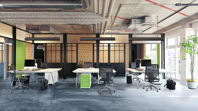 Open plan office with Comfortline Excel infrared ceiling heating panels above workstations on a concrete floor