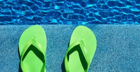 Green thongs beside a swimming pool on a warm summer day, illustrating outdoor and poolside heating comfort