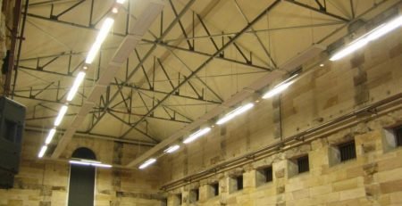 Comfortline radiant heating panels installed in heritage sandstone hall with exposed roof trusses