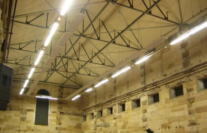 Comfortline radiant heating panels installed in heritage sandstone hall with exposed roof trusses