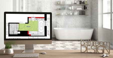 Computer displaying a bathroom floor plan with bathroom design lettering, in a modern Scandinavian bathroom