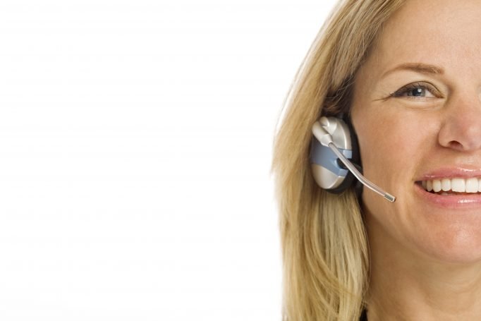 Smiling woman wearing a phone headset providing customer support