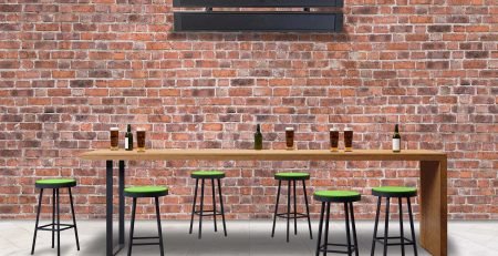 Comfortline infrared heater mounted above a pub bar area with exposed brick wall and green stools