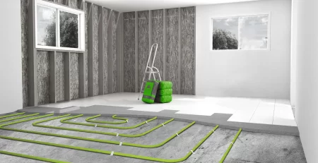 Hydronic underfloor heating pipes laid in serpentine pattern across concrete floor during construction