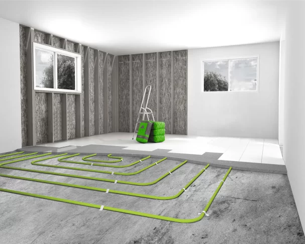 Hydronic underfloor heating pipes laid in serpentine pattern across concrete floor during construction