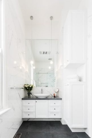 Elegant white marble bathroom with vessel sink, pendant lighting and dark slate floor tiles with underfloor heating