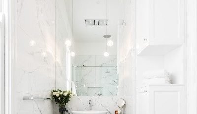 Elegant white marble bathroom with vessel sink, pendant lighting and dark slate floor tiles with underfloor heating