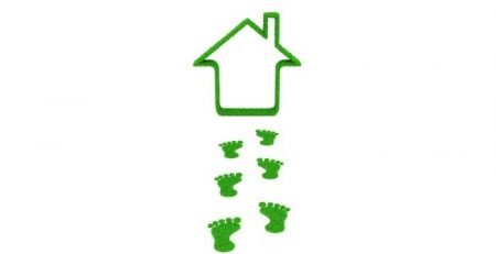 Eco-friendly home concept with green footprints leading to a grass house outline