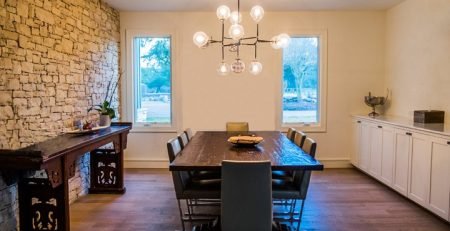 Modern dining room with timber floors and stone feature wall showing underfloor heating application